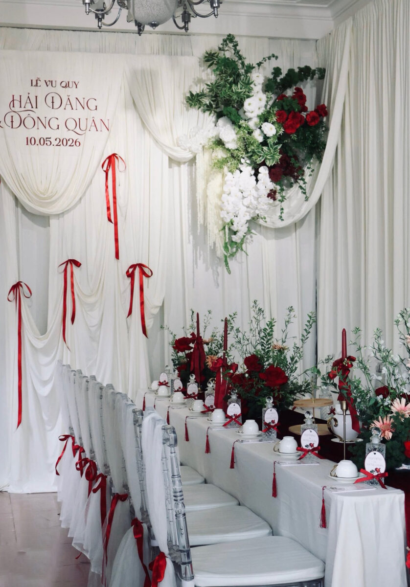 Decor ăn hỏi gia tiên phong cách tối giản với nền trắng tinh khôi, điểm nơ đỏ và ghế acrylic trong suốt.