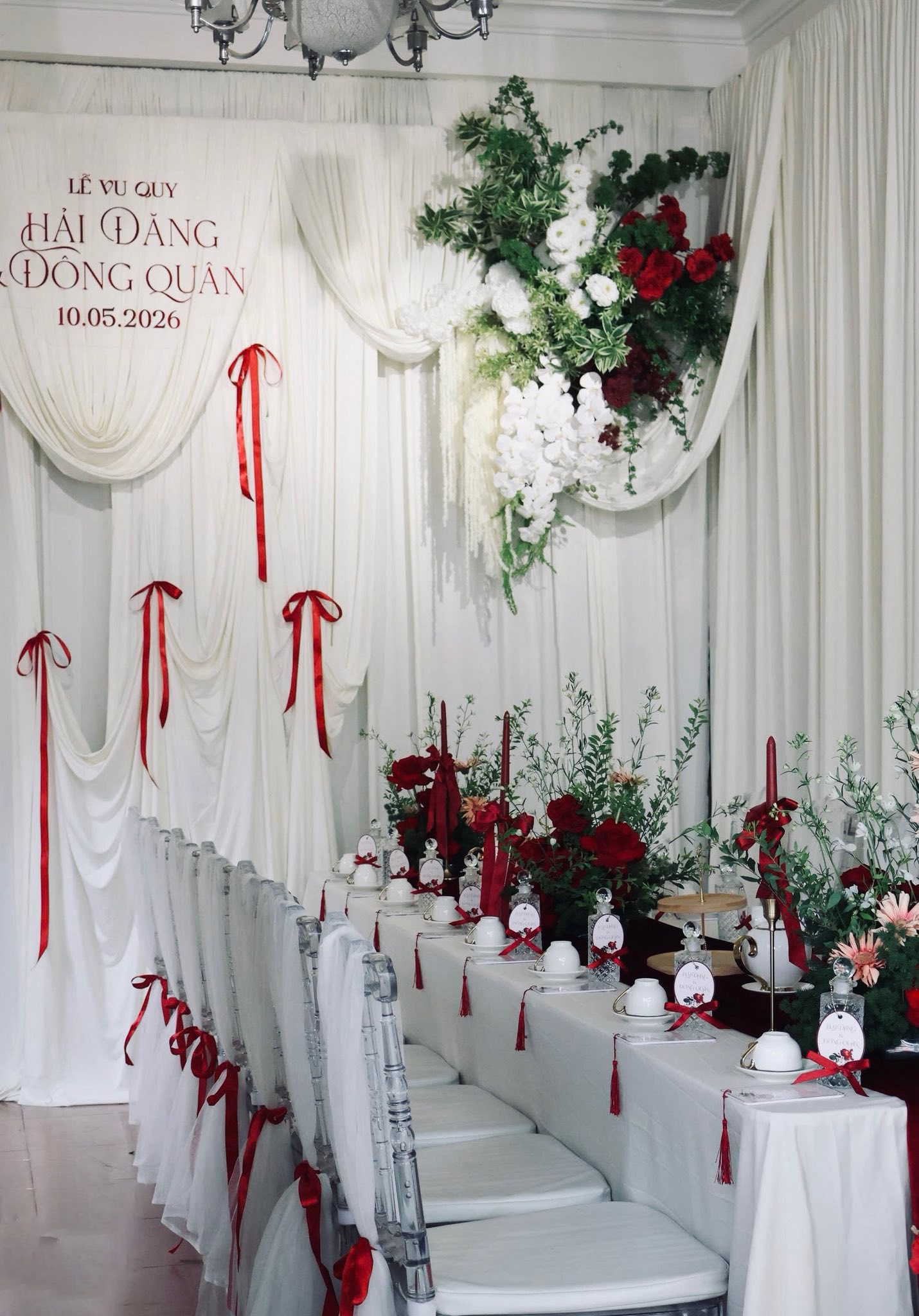 Decor ăn hỏi gia tiên phong cách tối giản với nền trắng tinh khôi, điểm nơ đỏ và ghế acrylic trong suốt.